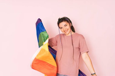 Pembe arka planda LGBT bayrağı olan bir kız.