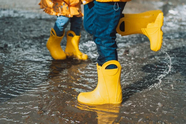 Children Yellow Rubber Boots Jumping Puddles — стоковое фото