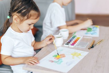 The child painted flowers and the sun with paints.