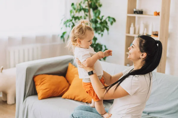 Genç anne kızı kucağında holding.