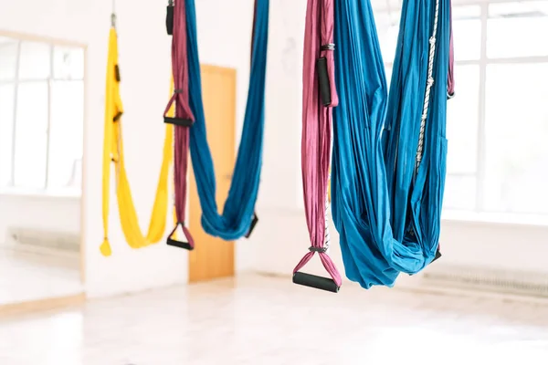 Hanging hammocks in front of a mirror in the fly yoga room.