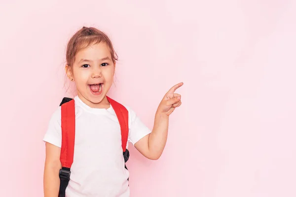 Surprised Little Girl Red Briefcase Points Her Finger Pink Background — Zdjęcie stockowe