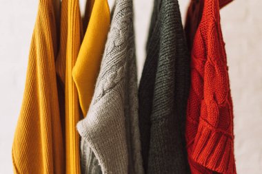 Çok renkli tişörtler ahşap askılarda asılı..