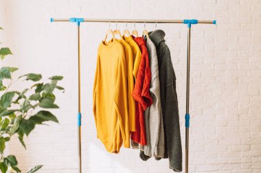 Ahşap askılarda çok renkli eşofman üstü asılı..