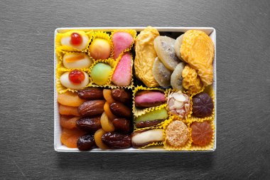 Ortasında beyaz metal tepsi, şekerli ve kuru meyveli..