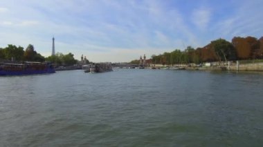Sen Nehri 'nden Pont Alexandre III' e doğru Eiffel Kulesi 'nin arkasında ve diğer tarafa giden iki penyeyle çekim yapılıyor..