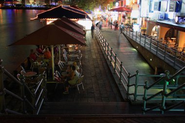 Downtown Core, Singapur - 22 Ağustos 2007: Boat Quay 'deki kanalın yanındaki bir kafe terasındaki insanlar.