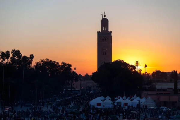 モロッコのマラケシュにあるクトゥビア モスクと日没時のジェマ フナの市場の場所 — ストック写真