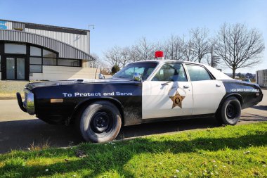 Pofolk, ABD - 23 Mart 2022: Eski Dodge Monaco otoban devriye arabası bir dükkanın yazı tipinde park edilmiş.