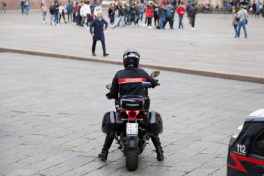 Bologna, İtalya - 02 Nisan 2019: Jandarma motosikletiyle eski kentte Piazza Maggiore 'da bekliyor.