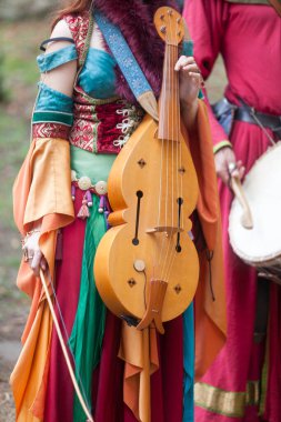 Ortaçağ kadın ozanı, Fransa 'nın Luzarches kentinde düzenlenen' Ortaçağ 'festivalinde bir davulcunun yanında vielle tutuyor..