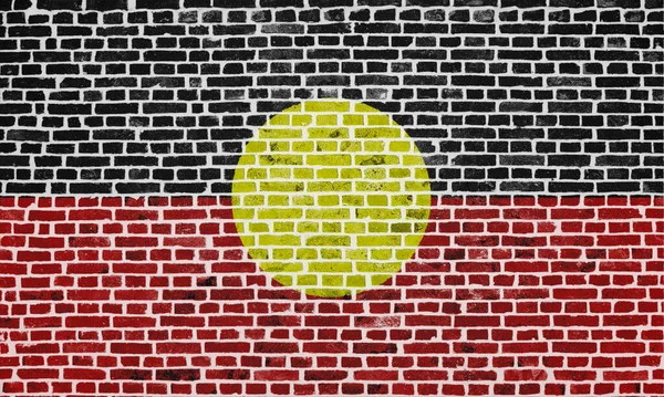 Zbliżenie Ceglanej Ścianie Flagą Australijskiego Aborygena Namalowaną Niej — Zdjęcie stockowe