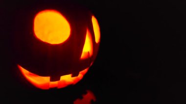Close-up on a Jack O Lantern glowing in the dark