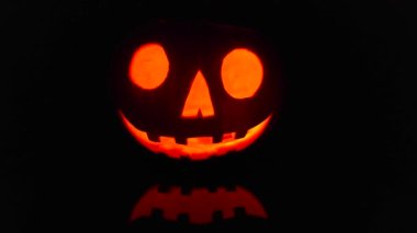 Close-up on a Jack O Lantern glowing in the dark