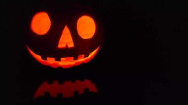 Close-up on a Jack O Lantern glowing in the dark