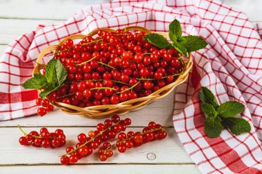 Masadaki saman tabağında taze üzümlü üzümler. Nane şekerleri. Beyaz ve kırmızı arka plan. Yukarıdan görüntüle.