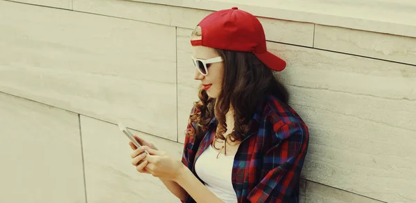 Подросток Смартфоном Красной Бейсболке Сидит Городском Парке — стоковое фото