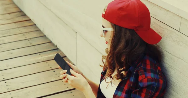 Подросток Смартфоном Красной Бейсболке Сидит Городском Парке — стоковое фото