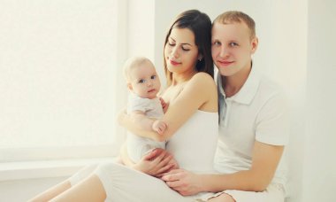 Evde bebekle mutlu bir anne ve babanın aile portresi