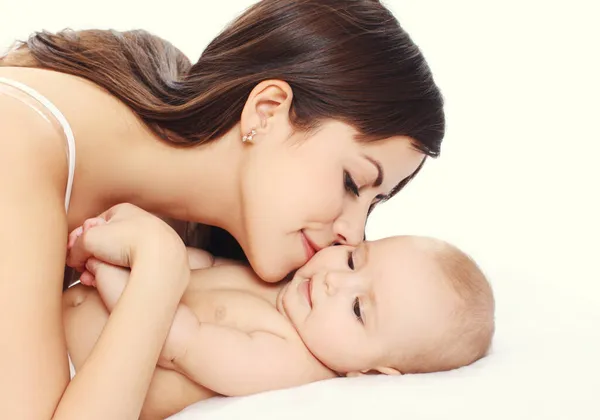 Retrato Close Feliz Jovem Mãe Beijando Seu Bebê Deitado Cama — Fotografia de Stock