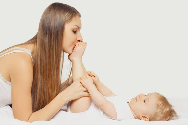 Glückliche Junge Mutter Küsst Füße Ihres Babys Hause Liegend Auf — Stockfoto