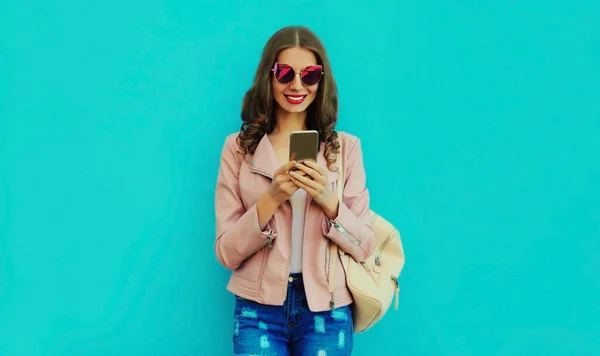 Portret Uśmiechniętej Młodej Kobiety Smartfonem Niebieskim Tle — Zdjęcie stockowe