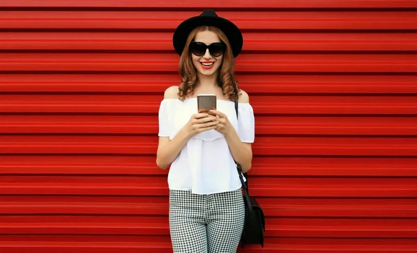Portret Van Vrolijke Glimlachende Jonge Vrouw Met Smartphone Rode Achtergrond — Stockfoto