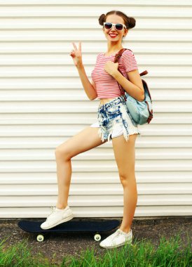 Beyaz bir arka planda kaykaylı neşeli genç bir kadının yaz portresi.