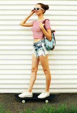 Beyaz bir arka planda kaykaylı neşeli genç bir kadının yaz portresi.