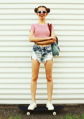 Beyaz bir arka planda kaykaylı neşeli genç bir kadının yaz portresi.