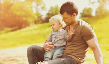 Mutlu baba ve oğul portresi. Yaz parkında ellerdeydi.