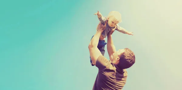 快乐的父亲和儿子在蓝天的背景下在户外玩耍 — 图库照片