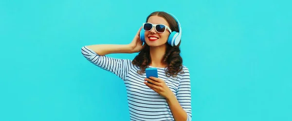 Портрет Усміхненої Молодої Жінки Навушниках Слухає Музику Смартфоном Синьому Фоні — стокове фото