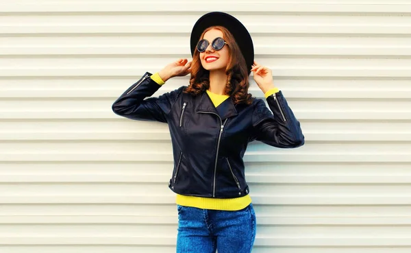 黒のロックスタイルのジャケットを身に着けているポーズスタイリッシュな若い女性モデルのファッショナブルな肖像画 白の背景に黄色のセーター — ストック写真