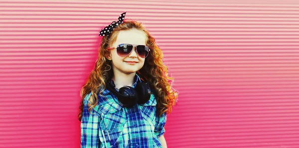毛茸茸的小女孩身穿格子衬衫 戴着粉色背景太阳镜的画像 — 图库照片