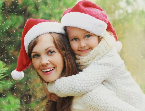 Weihnachtsporträt Von Glücklich Lächelnder Mutter Und Kleinem Mädchen Mit Weihnachtsmannmütze — Stockfoto