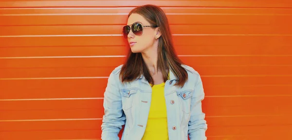 オレンジ色の壁の背景に街でサングラスをかけて美しい若い女性の夏の肖像画 — ストック写真