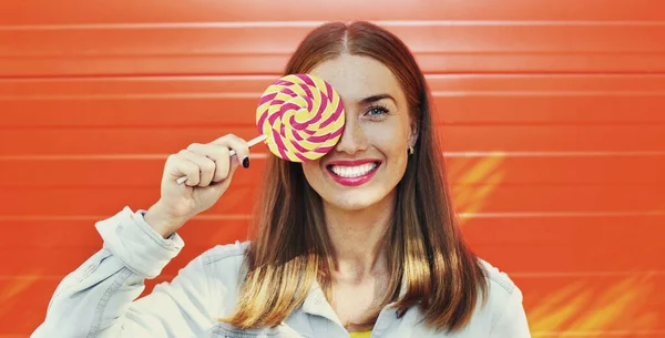 Letni Kolorowy Portret Szczęśliwej Uśmiechniętej Młodej Kobiety Lizakiem Pomarańczowym Tle — Zdjęcie stockowe