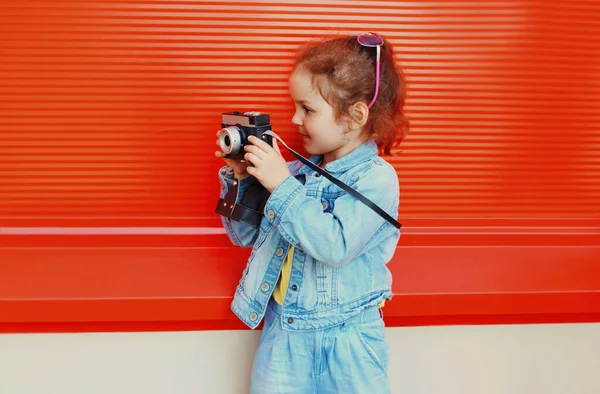 Malá Dívka Dítě Retro Kamerou Pořízení Fotografie Městě Červeném Pozadí — Stock fotografie
