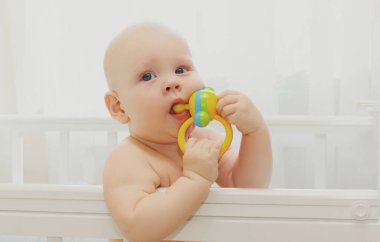 Evdeki yatağın üzerinde oyuncak olan şirin bir bebek portresi.