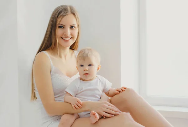 Lächelnde Mutter Und Kleines Baby Sitzen Zusammen Weißem Zimmer Hause — Stockfoto