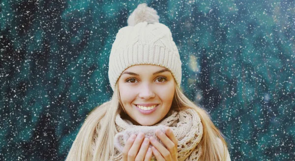 雪の上で冬にニット帽とスカーフを着て幸せな笑顔の若い女性の肖像画背景 — ストック写真