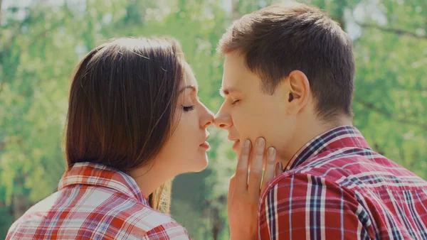 一对快乐的年轻夫妇在户外接吻的肖像 — 图库照片