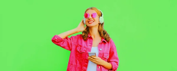 Portret Stylowej Uśmiechniętej Młodej Kobiety Słuchawkach Smartfonem Słuchającym Muzyki Różowej — Zdjęcie stockowe