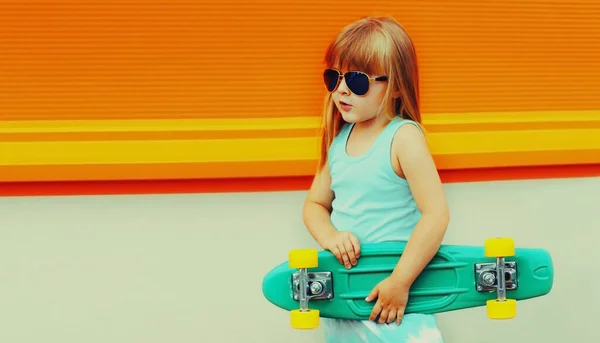 城市街道上有滑板的时髦小女孩的画像 — 图库照片