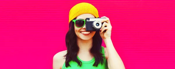幸せな笑顔若い女性写真家の夏のカラフルな肖像画ピンクの背景にカメラで写真を撮る 広告テキストのための空白のコピースペース — ストック写真