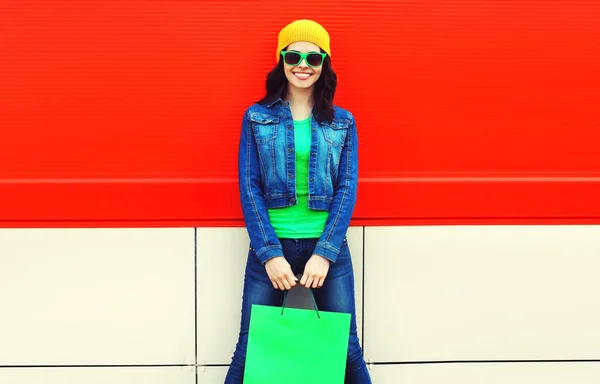 カラフルな背景にショッピングバッグと美しい幸せな笑顔の若い女性の肖像画 — ストック写真