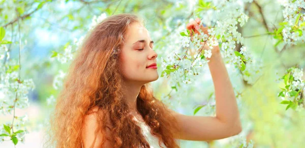 Baharda Çiçek Açan Bahçesinde Uzun Kıvırcık Saçlı Güzel Bir Genç — Stok fotoğraf