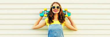 Beyaz arka planda yeşil kaykaylı gülümseyen genç bir kadının yaz portresi.