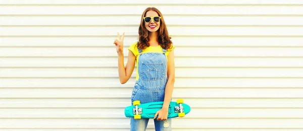幸せな笑顔若い女性の夏の肖像画ともに緑のスケートボード上の白い背景 — ストック写真